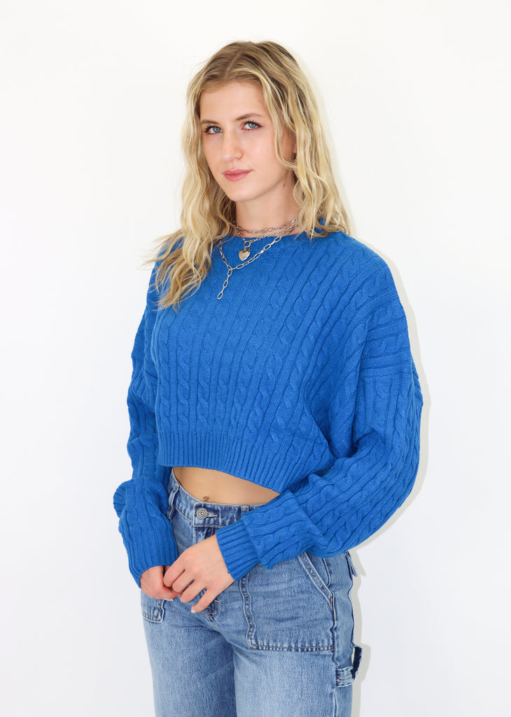 Blue cropped cable knit sweater. Ribbed neckline and cuffs.