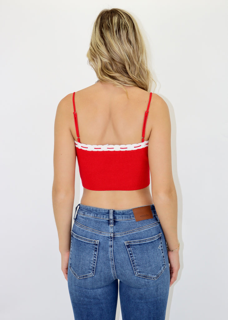 Cropped tank top, red string trim, small bow in the front, adjustable straps, red