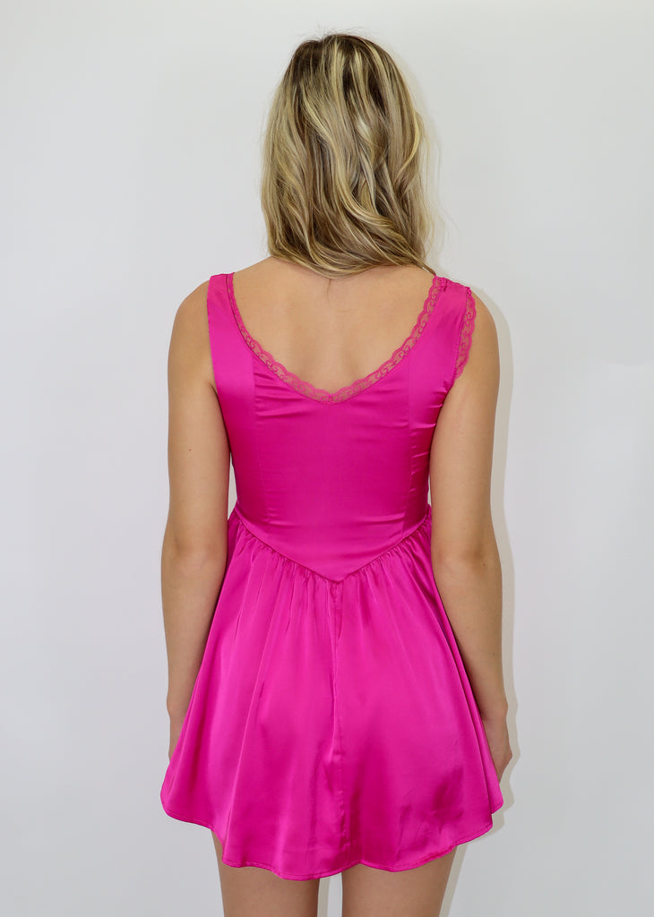 hot pink corset dress with lace detailing along straps with bow and ruffle skirt detail