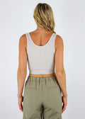 Cropped ribbed white colored tank, three button enclosures in front.