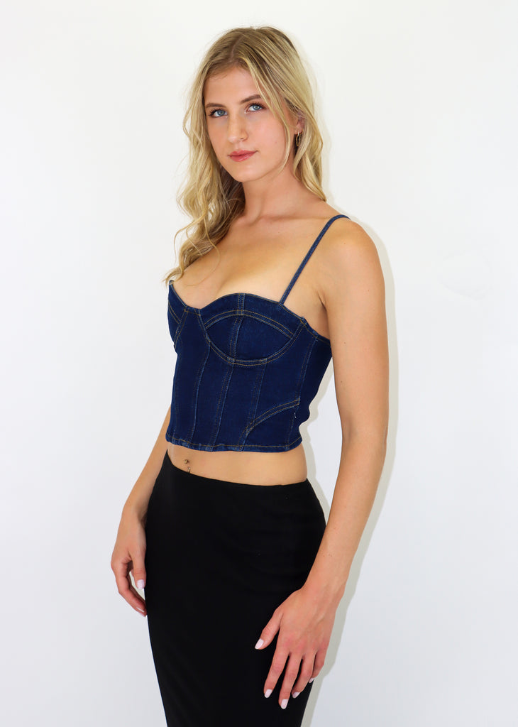 Corset top with lace up back, adjustable ties and a denim material.