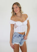 white bustier bra corset style top lace sides short sleeves off the shoulder hook and eye closure on front lace trim on sleeves and bra cropped length going out top spring summer neutral women's clothing