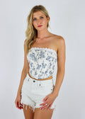 Strapless white corset tank, blue flower print. Lace trim detailing on top, small bow front center. 