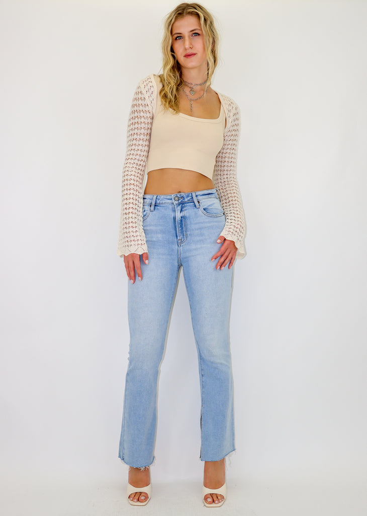 Light wash jeans features a slit hem and a high waisted fit.
