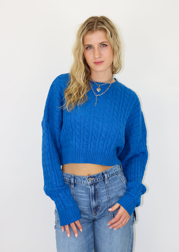 Blue cropped cable knit sweater. Ribbed neckline and cuffs.