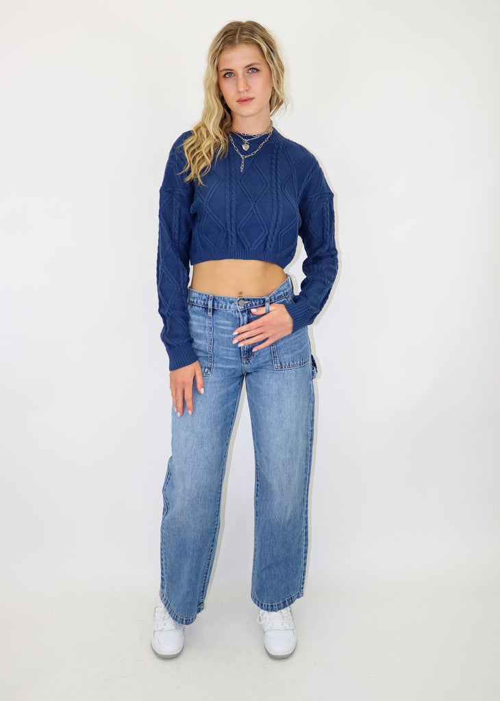 Blue cable knit sweater, cropped fit. Ribbed neckline and cuffs.