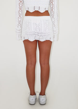 White crochet mini skirt, ribbed waist, scalloped hem.