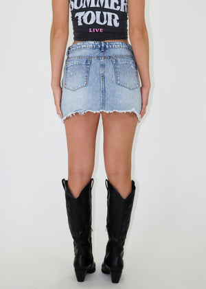Light wash denim mini skirt features distressed denim material, pockets in the front and back.