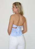 Strapless blue floral top features a smocked waist and ruffle hem with a tie back.