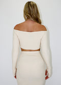 Cropped cream long sleeved knit sweater with thumb hole sleeves.