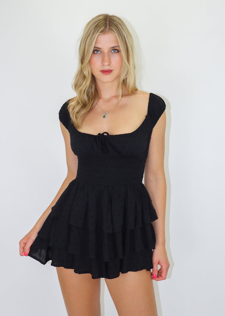  Black romper featuring Dobby Dot fabric, a smocked waist and tiered bottom.