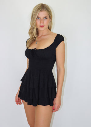 Black romper featuring Dobby Dot fabric, a smocked waist and tiered bottom.