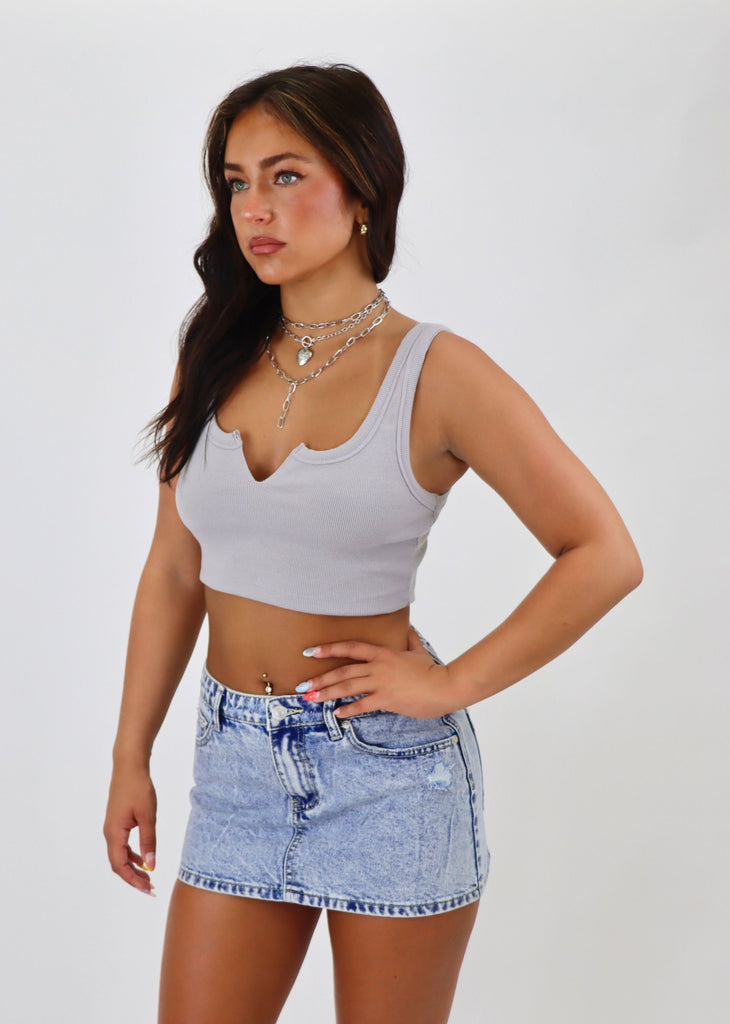 Stay chic and comfortable in our grey ribbed notch slit neck cropped tank top. Perfect for a casual day out or dressing up for a night on the town. Made with high-quality ribbed fabric, this tank top features a trendy slit neck design for added flair. Pair it with your favorite high-waisted jeans or a flowy skirt for a versatile and stylish look.