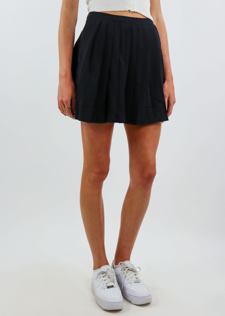 black mini tennis skirt with pleating throughout the body and invisible zipper