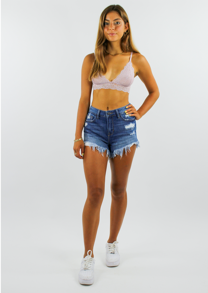 Women's dark wash high rise denim jean shorts with distressing on front pockets and frayed bottom seams.