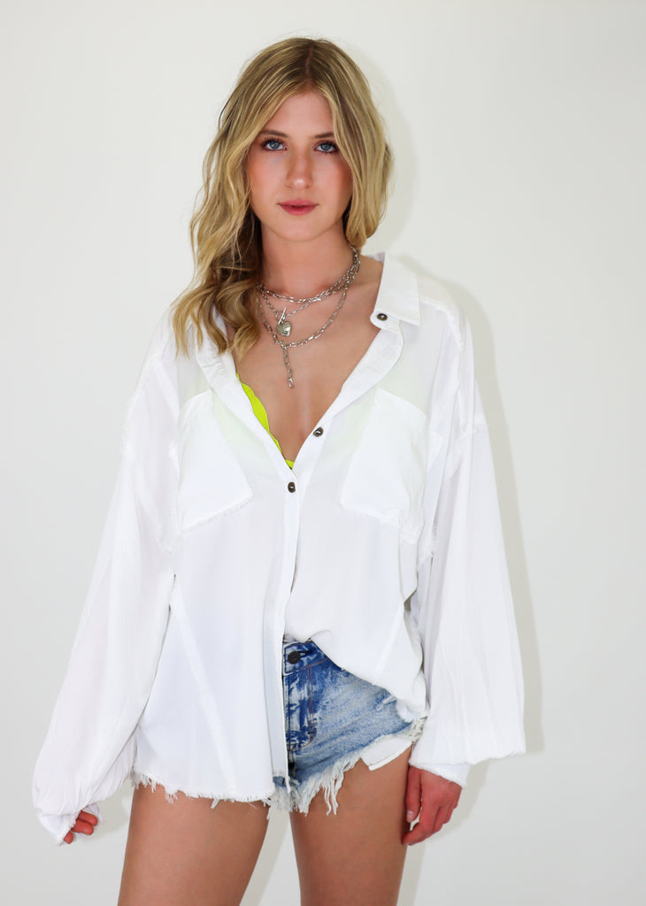 white oversized button up elongated balloon long sleeve top dual front pockets frayed hem and seams blouse beach pool cover up closet essential basics neutral spring break festival season women's clothing