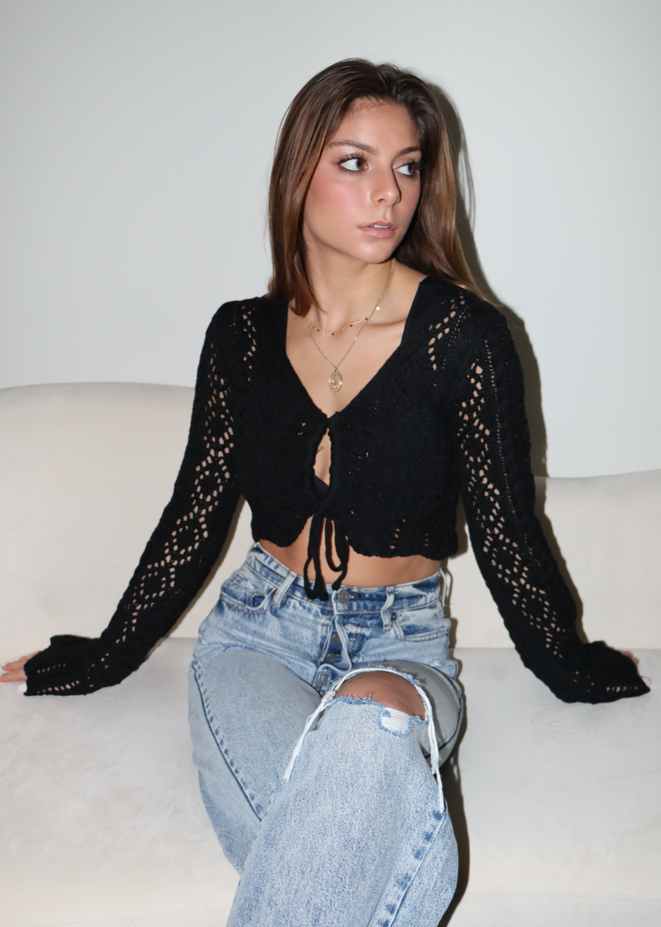 Women's black crochet cropped cardigan sweater with keyhole tie front and bell sleeves.