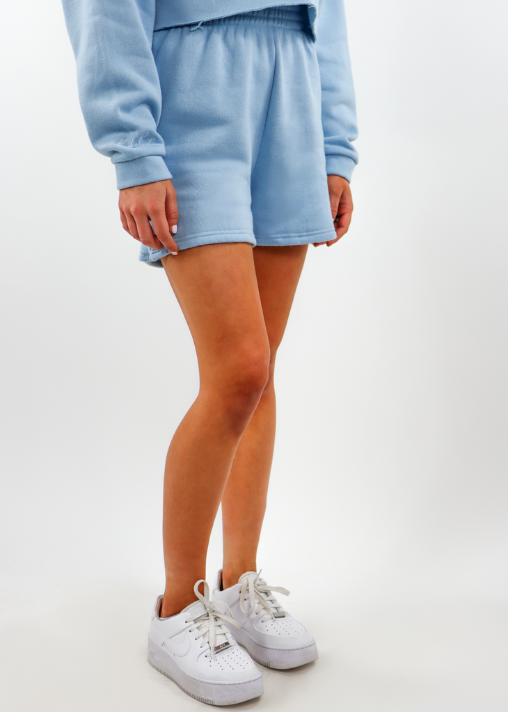 light blue baby blue sweat shorts with two front pockets and an elastic waistline. Another Pocket in Back with Embroidered logo. Can be bought in a matching set with the matching cropped jacket