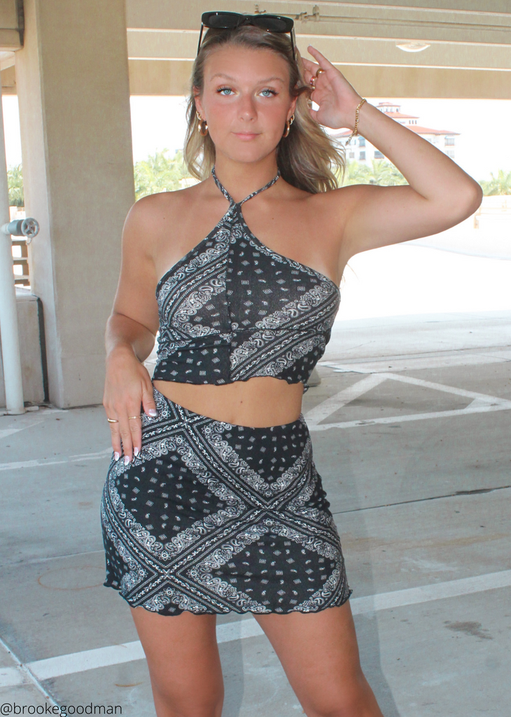 black paisley halter crop top with lettuce trim, exposed seams detailing on front, and an open back
